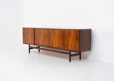 Rare XL sideboard in rosewood by Ib Kofod-Larsen for Faarup (Denmark, 1950s). This piece exudes pure luxury, featuring four large sliding doors with amazing inset handles and lots of storage space with adjustable drawers and shelves inside. The exterior is crafted from rosewood with a glossy finish, showcasing a stunning woodgrain, while the oak-finished interior provides a beautiful contrast. This hard to find piece presents itself in amazing vintage condition with minimal sings of a previous life. The doors slide really smooth. Marked by maker.