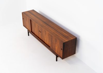 Rare XL sideboard in rosewood by Ib Kofod-Larsen for Faarup (Denmark, 1950s). This piece exudes pure luxury, featuring four large sliding doors with amazing inset handles and lots of storage space with adjustable drawers and shelves inside. The exterior is crafted from rosewood with a glossy finish, showcasing a stunning woodgrain, while the oak-finished interior provides a beautiful contrast. This hard to find piece presents itself in amazing vintage condition with minimal sings of a previous life. The doors slide really smooth. Marked by maker.