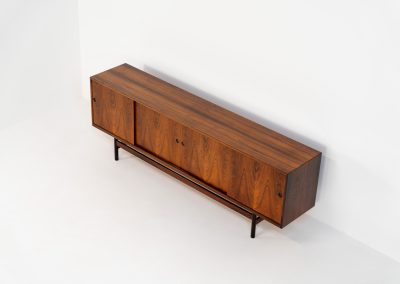 Rare XL sideboard in rosewood by Ib Kofod-Larsen for Faarup (Denmark, 1950s). This piece exudes pure luxury, featuring four large sliding doors with amazing inset handles and lots of storage space with adjustable drawers and shelves inside. The exterior is crafted from rosewood with a glossy finish, showcasing a stunning woodgrain, while the oak-finished interior provides a beautiful contrast. This hard to find piece presents itself in amazing vintage condition with minimal sings of a previous life. The doors slide really smooth. Marked by maker.