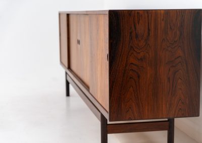 Rare XL sideboard in rosewood by Ib Kofod-Larsen for Faarup (Denmark, 1950s). This piece exudes pure luxury, featuring four large sliding doors with amazing inset handles and lots of storage space with adjustable drawers and shelves inside. The exterior is crafted from rosewood with a glossy finish, showcasing a stunning woodgrain, while the oak-finished interior provides a beautiful contrast. This hard to find piece presents itself in amazing vintage condition with minimal sings of a previous life. The doors slide really smooth. Marked by maker.