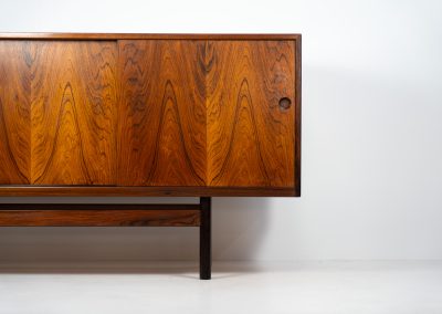 Rare XL sideboard in rosewood by Ib Kofod-Larsen for Faarup (Denmark, 1950s). This piece exudes pure luxury, featuring four large sliding doors with amazing inset handles and lots of storage space with adjustable drawers and shelves inside. The exterior is crafted from rosewood with a glossy finish, showcasing a stunning woodgrain, while the oak-finished interior provides a beautiful contrast. This hard to find piece presents itself in amazing vintage condition with minimal sings of a previous life. The doors slide really smooth. Marked by maker.