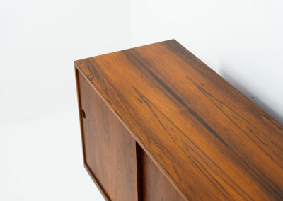 Rare XL sideboard in rosewood by Ib Kofod-Larsen for Faarup (Denmark, 1950s). This piece exudes pure luxury, featuring four large sliding doors with amazing inset handles and lots of storage space with adjustable drawers and shelves inside. The exterior is crafted from rosewood with a glossy finish, showcasing a stunning woodgrain, while the oak-finished interior provides a beautiful contrast. This hard to find piece presents itself in amazing vintage condition with minimal sings of a previous life. The doors slide really smooth. Marked by maker.