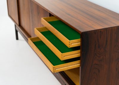 Rare XL sideboard in rosewood by Ib Kofod-Larsen for Faarup (Denmark, 1950s). This piece exudes pure luxury, featuring four large sliding doors with amazing inset handles and lots of storage space with adjustable drawers and shelves inside. The exterior is crafted from rosewood with a glossy finish, showcasing a stunning woodgrain, while the oak-finished interior provides a beautiful contrast. This hard to find piece presents itself in amazing vintage condition with minimal sings of a previous life. The doors slide really smooth. Marked by maker.