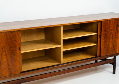 Rare XL sideboard in rosewood by Ib Kofod-Larsen for Faarup (Denmark, 1950s). This piece exudes pure luxury, featuring four large sliding doors with amazing inset handles and lots of storage space with adjustable drawers and shelves inside. The exterior is crafted from rosewood with a glossy finish, showcasing a stunning woodgrain, while the oak-finished interior provides a beautiful contrast. This hard to find piece presents itself in amazing vintage condition with minimal sings of a previous life. The doors slide really smooth. Marked by maker.