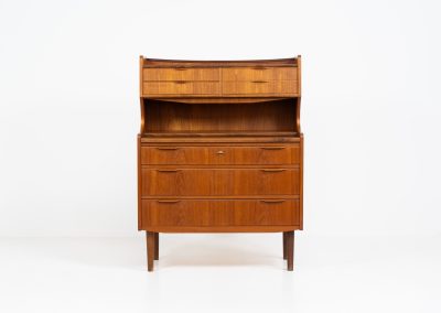 Danish secretary in teak, 1960s. A highly versatile piece featuring seven drawers with beautiful handles, a pull-out leaf, a mirror and lots of storage space. A convenient piece that finds its way in any setting. In very good condition!