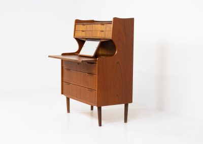 Danish secretary in teak, 1960s. A highly versatile piece featuring seven drawers with beautiful handles, a pull-out leaf, a mirror and lots of storage space. A convenient piece that finds its way in any setting. In very good condition!