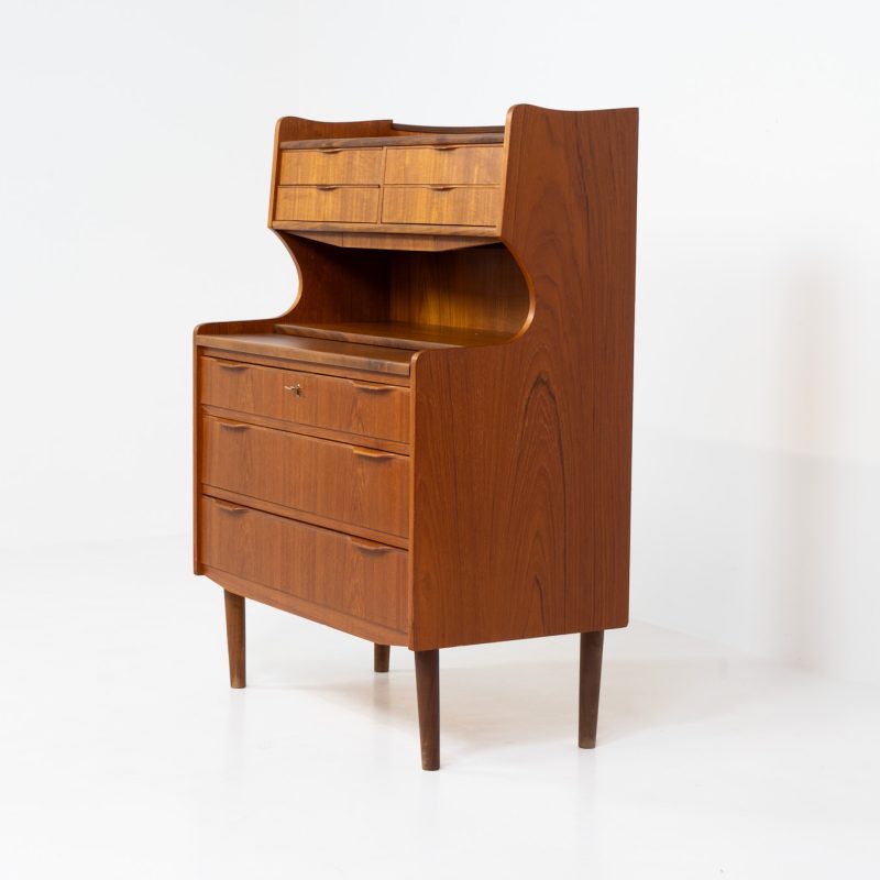 Danish secretary in teak, 1960s. A highly versatile piece featuring seven drawers with beautiful handles, a pull-out leaf, a mirror and lots of storage space. A convenient piece that finds its way in any setting. In very good condition!