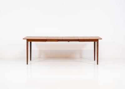 Large extendable dining table by Rastad & Relling for Gustav Bahus (Norway, 1950s). A stunning high-end teak dining table showcasing beautiful woodgrain, elegant curves, and a natural finish. Effortlessly extendable with one or two leaves, it adjusts from 130 cm to 175 cm or 220 cm, with extensions conveniently stored beneath the tabletop. This table remains in excellent condition.