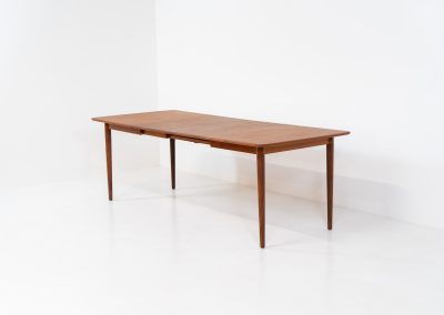 Large extendable dining table by Rastad & Relling for Gustav Bahus (Norway, 1950s). A stunning high-end teak dining table showcasing beautiful woodgrain, elegant curves, and a natural finish. Effortlessly extendable with one or two leaves, it adjusts from 130 cm to 175 cm or 220 cm, with extensions conveniently stored beneath the tabletop. This table remains in excellent condition.