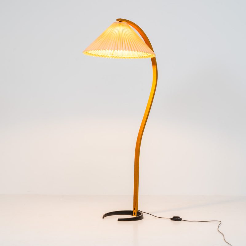 Magnificent Caprani floor lamp by Mads Caprani (Denmark, 1970s). This iconic and hard to find piece features a graceful beech ark, a cast iron base and its original linen pleated shade. The lamp is in original and very good condition, with only minor using traces on the shade, as shown on the pictures. Labeled by maker.