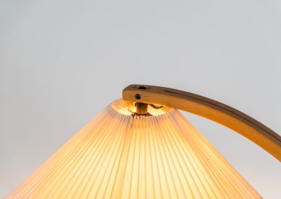 Magnificent Caprani floor lamp by Mads Caprani (Denmark, 1970s). This iconic and hard to find piece features a graceful beech ark, a cast iron base and its original linen pleated shade. The lamp is in original and very good condition, with only minor using traces on the shade, as shown on the pictures. Labeled by maker.