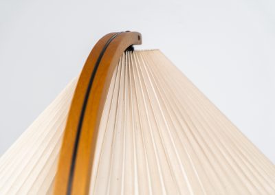 Magnificent Caprani floor lamp by Mads Caprani (Denmark, 1970s). This iconic and hard to find piece features a graceful beech ark, a cast iron base and its original linen pleated shade. The lamp is in original and very good condition, with only minor using traces on the shade, as shown on the pictures. Labeled by maker.