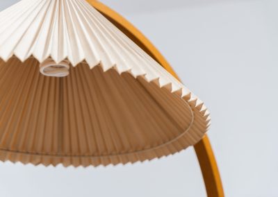 Magnificent Caprani floor lamp by Mads Caprani (Denmark, 1970s). This iconic and hard to find piece features a graceful beech ark, a cast iron base and its original linen pleated shade. The lamp is in original and very good condition, with only minor using traces on the shade, as shown on the pictures. Labeled by maker.