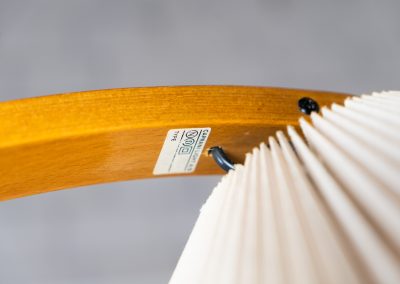 Magnificent Caprani floor lamp by Mads Caprani (Denmark, 1970s). This iconic and hard to find piece features a graceful beech ark, a cast iron base and its original linen pleated shade. The lamp is in original and very good condition, with only minor using traces on the shade, as shown on the pictures. Labeled by maker.