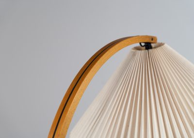 Magnificent Caprani floor lamp by Mads Caprani (Denmark, 1970s). This iconic and hard to find piece features a graceful beech ark, a cast iron base and its original linen pleated shade. The lamp is in original and very good condition, with only minor using traces on the shade, as shown on the pictures. Labeled by maker.