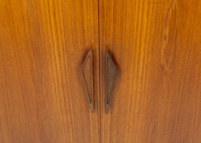 Danish highboard in teak, 1960s. A beautiful mid-century piece crafted in rich teak wood, featuring two spacious doors and two smooth-sliding doors, offering lots of storage and a stylish bar unit inside. The highboard showcases a warm, natural woodgrain, elegant rounded edges, and distinctive handles. It is in very good condition with mild age-related marks.