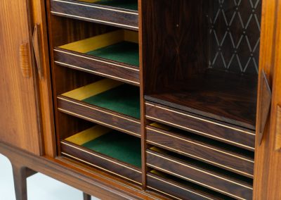 Danish highboard in teak, 1960s. A beautiful mid-century piece crafted in rich teak wood, featuring two spacious doors and two smooth-sliding doors, offering lots of storage and a stylish bar unit inside. The highboard showcases a warm, natural woodgrain, elegant rounded edges, and distinctive handles. It is in very good condition with mild age-related marks.