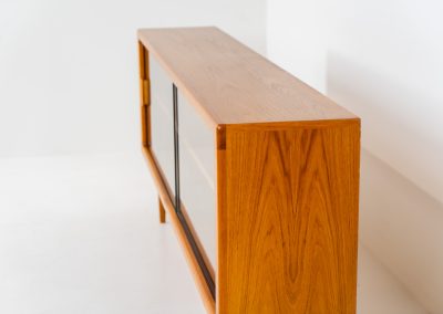 Stunning sideboard with glass doors by CFC Silkeborg (Denmark, 1960s). This elegant mid-century piece, crafted in teak, features beautifully rounded edges, sleek glass sliding doors, and refined wooden handles. Its timeless design combines style with functionality, offering lots of storage space with two adjustable shelves inside. Notably versatile, the sideboard includes three wall mounts on the back, allowing it to be used as a floating sideboard if desired. The legs can be easily removed for this purpose. In very good condition, with only two small repair marks.