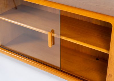 Stunning sideboard with glass doors by CFC Silkeborg (Denmark, 1960s). This elegant mid-century piece, crafted in teak, features beautifully rounded edges, sleek glass sliding doors, and refined wooden handles. Its timeless design combines style with functionality, offering lots of storage space with two adjustable shelves inside. Notably versatile, the sideboard includes three wall mounts on the back, allowing it to be used as a floating sideboard if desired. The legs can be easily removed for this purpose. In very good condition, with only two small repair marks.