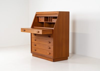 Magnificent secretary by Bent Møller Jørgensen for Svend Dyrlund (Denmark, 1960s). This is an example of high quality Danish craftsmanship. It features stunning aesthetics and nifty details like the tambour door that opens automatically if you pull the upper drawer or the beautiful Dyrlund signature handles. It is in splendid condition and marked by the maker.