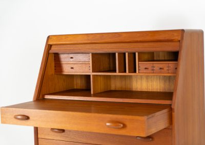 Magnificent secretary by Bent Møller Jørgensen for Svend Dyrlund (Denmark, 1960s). This is an example of high quality Danish craftsmanship. It features stunning aesthetics and nifty details like the tambour door that opens automatically if you pull the upper drawer or the beautiful Dyrlund signature handles. It is in splendid condition and marked by the maker.