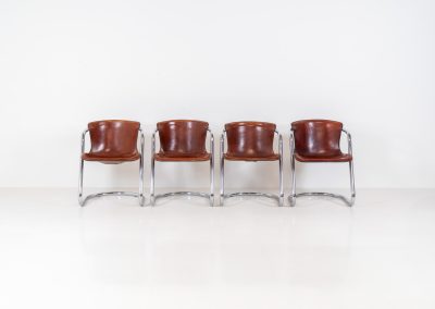 Set of 4 rare leather dining chairs by Willy Rizzo for Metaform (the Netherlands, 1970s). Designed in Italy and manufactured in the Netherlands, these hard to find chairs are a testament to Willy Rizzo’s iconic style. They feature chrome tubular frames and cognac leather seats. The leather showcases a rich patina with visible signs of use, adding character and charm to these remarkable pieces.