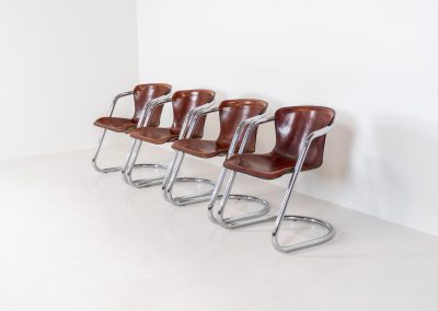 Set of 4 rare leather dining chairs by Willy Rizzo for Metaform (the Netherlands, 1970s). Designed in Italy and manufactured in the Netherlands, these hard to find chairs are a testament to Willy Rizzo’s iconic style. They feature chrome tubular frames and cognac leather seats. The leather showcases a rich patina with visible signs of use, adding character and charm to these remarkable pieces.