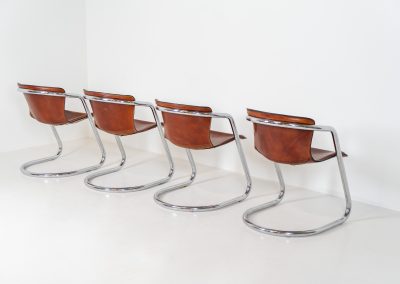 Set of 4 rare leather dining chairs by Willy Rizzo for Metaform (the Netherlands, 1970s). Designed in Italy and manufactured in the Netherlands, these hard to find chairs are a testament to Willy Rizzo’s iconic style. They feature chrome tubular frames and cognac leather seats. The leather showcases a rich patina with visible signs of use, adding character and charm to these remarkable pieces.