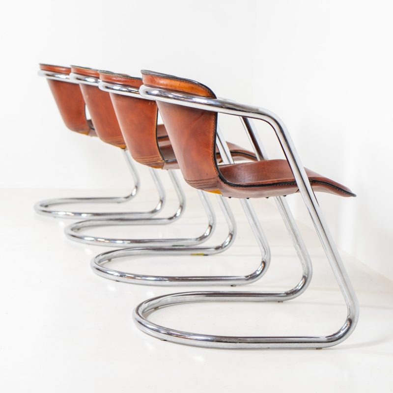 Set of 4 rare leather dining chairs by Willy Rizzo for Metaform (the Netherlands, 1970s). Designed in Italy and manufactured in the Netherlands, these hard to find chairs are a testament to Willy Rizzo’s iconic style. They feature chrome tubular frames and cognac leather seats. The leather showcases a rich patina with visible signs of use, adding character and charm to these remarkable pieces.