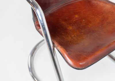 Set of 4 rare leather dining chairs by Willy Rizzo for Metaform (the Netherlands, 1970s). Designed in Italy and manufactured in the Netherlands, these hard to find chairs are a testament to Willy Rizzo’s iconic style. They feature chrome tubular frames and cognac leather seats. The leather showcases a rich patina with visible signs of use, adding character and charm to these remarkable pieces.