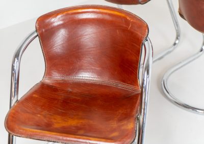 Set of 4 rare leather dining chairs by Willy Rizzo for Metaform (the Netherlands, 1970s). Designed in Italy and manufactured in the Netherlands, these hard to find chairs are a testament to Willy Rizzo’s iconic style. They feature chrome tubular frames and cognac leather seats. The leather showcases a rich patina with visible signs of use, adding character and charm to these remarkable pieces.