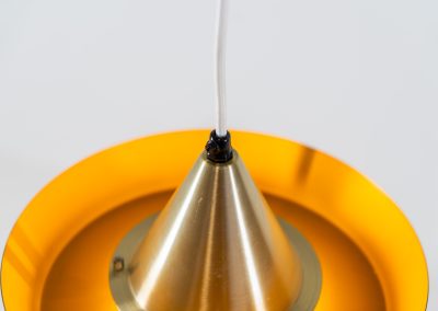 Beautiful messing pendant light by Carl Thore for Granhaga (Sweden, 1960s). This striking mid-century lamp showcases a sophisticated blend of geometric lines and warm metallic tones. Its layered design, combining matte black and brass with a subtle orange interior, creates a stunning interplay of light and shadow. The lamp is rewired and remains in excellent condition.