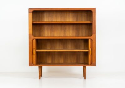 Beautiful bookcase in teak by Svend Dyrlund with tambour doors (Denmark, 1960s). This bookcase perfectly combines organic shapes and loads of detail, like the tambour sliding doors, the beautiful handles or the bulky shelves, which are adjustable in height. It offers lots of storage space! In mint condition!