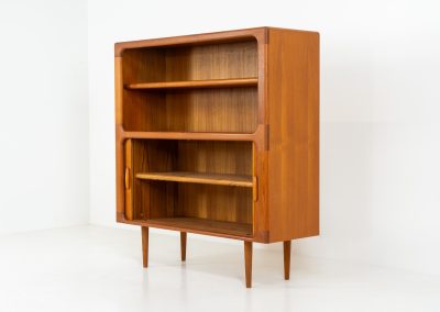Beautiful bookcase in teak by Svend Dyrlund with tambour doors (Denmark, 1960s). This bookcase perfectly combines organic shapes and loads of detail, like the tambour sliding doors, the beautiful handles or the bulky shelves, which are adjustable in height. It offers lots of storage space! In mint condition!