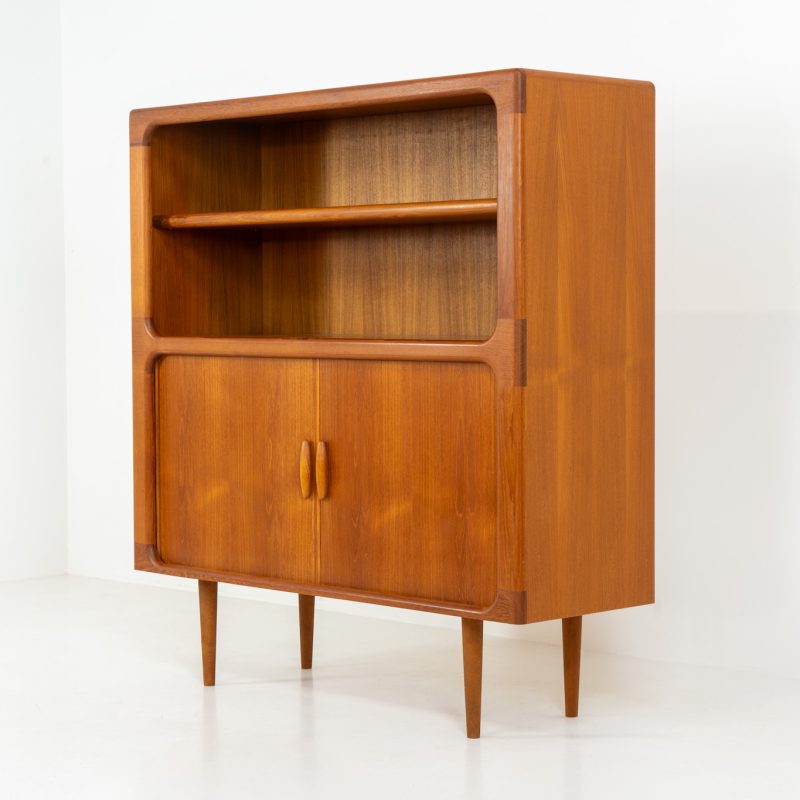 Beautiful bookcase in teak by Svend Dyrlund with tambour doors (Denmark, 1960s). This bookcase perfectly combines organic shapes and loads of detail, like the tambour sliding doors, the beautiful handles or the bulky shelves, which are adjustable in height. It offers lots of storage space! In mint condition!