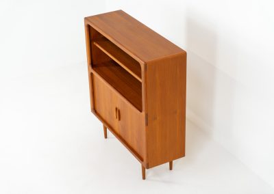 Beautiful bookcase in teak by Svend Dyrlund with tambour doors (Denmark, 1960s). This bookcase perfectly combines organic shapes and loads of detail, like the tambour sliding doors, the beautiful handles or the bulky shelves, which are adjustable in height. It offers lots of storage space! In mint condition!