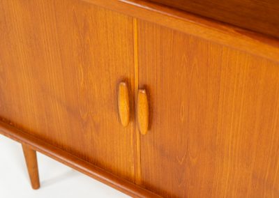 Beautiful bookcase in teak by Svend Dyrlund with tambour doors (Denmark, 1960s). This bookcase perfectly combines organic shapes and loads of detail, like the tambour sliding doors, the beautiful handles or the bulky shelves, which are adjustable in height. It offers lots of storage space! In mint condition!