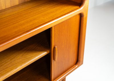 Beautiful bookcase in teak by Svend Dyrlund with tambour doors (Denmark, 1960s). This bookcase perfectly combines organic shapes and loads of detail, like the tambour sliding doors, the beautiful handles or the bulky shelves, which are adjustable in height. It offers lots of storage space! In mint condition!