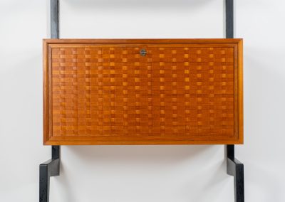 Extremely rare standing wall-unit with bar by Poul Cadovius (Denmark, 1960s). A true masterpiece of Danish modernism and a model we have never seen before! It features two metal Z-shaped wall supports, three normal shelves, one slightly wider shelve and a bar cabinet with amazing details like the bentwood shelves on the inside, the woven teak door or the build-in bottle rack. This extraordinary piece presents itself in mint condition!