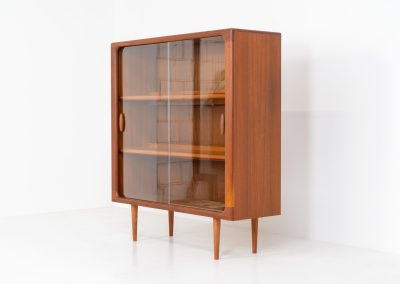 Stunning showcase by Svend Dyrlund (Denmark, 1960s). This exceptional piece features elegant glass doors with beautifully crafted wooden handles, two adjustable shelves, and convenient backlights behind each shelf to highlight your displayed items. Made from rich teak with a natural woodgrain, it perfectly combines functionality with the timeless characteristic of Danish modern design. In splendid condition.