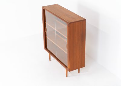 Stunning showcase by Svend Dyrlund (Denmark, 1960s). This exceptional piece features elegant glass doors with beautifully crafted wooden handles, two adjustable shelves, and convenient backlights behind each shelf to highlight your displayed items. Made from rich teak with a natural woodgrain, it perfectly combines functionality with the timeless characteristic of Danish modern design. In splendid condition.