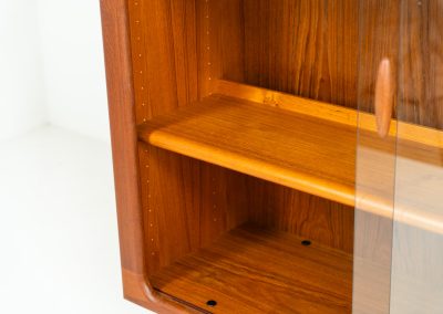 Stunning showcase by Svend Dyrlund (Denmark, 1960s). This exceptional piece features elegant glass doors with beautifully crafted wooden handles, two adjustable shelves, and convenient backlights behind each shelf to highlight your displayed items. Made from rich teak with a natural woodgrain, it perfectly combines functionality with the timeless characteristic of Danish modern design. In splendid condition.