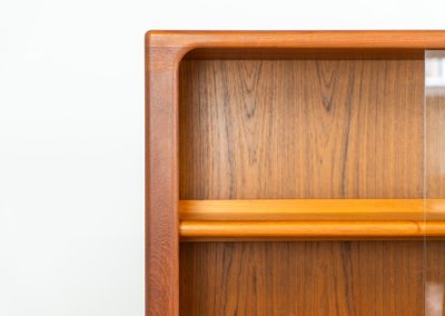 Stunning showcase by Svend Dyrlund (Denmark, 1960s). This exceptional piece features elegant glass doors with beautifully crafted wooden handles, two adjustable shelves, and convenient backlights behind each shelf to highlight your displayed items. Made from rich teak with a natural woodgrain, it perfectly combines functionality with the timeless characteristic of Danish modern design. In splendid condition.