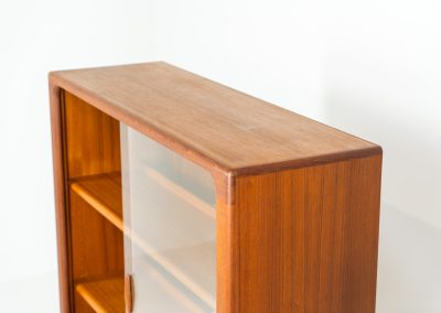 Stunning showcase by Svend Dyrlund (Denmark, 1960s). This exceptional piece features elegant glass doors with beautifully crafted wooden handles, two adjustable shelves, and convenient backlights behind each shelf to highlight your displayed items. Made from rich teak with a natural woodgrain, it perfectly combines functionality with the timeless characteristic of Danish modern design. In splendid condition.