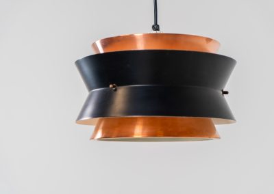 Copper pendant light by Vitrika (Denmark, 1960s). This elegant copper pendant lamp, designed by Vitrika Denmark, draws inspiration from Carl Thore’s iconic Trava models. Its sleek design features four copper shades, two of which are lacquered in black, creating a striking contrast. With its timeless, sophisticated appearance, this lamp seamlessly combines mid-century charm with modern elegance, making it a versatile addition to any interior. In very good condition.
