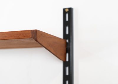 Beautiful wall-unit by Kai Kristiansen for FM Møbler (Denmark, 1960s). Just a stunning shelving system featuring three black metal wall mounts, six normal shelves and one extra wide shelve which can also be used as a small desk. The modular system allows for endless configuration possibilities, enabling you to arrange the pieces to suit your personal taste and space. The wall-unit remains in excellent condition!