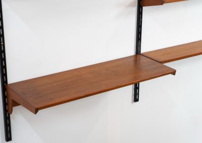 Beautiful wall-unit by Kai Kristiansen for FM Møbler (Denmark, 1960s). Just a stunning shelving system featuring three black metal wall mounts, six normal shelves and one extra wide shelve which can also be used as a small desk. The modular system allows for endless configuration possibilities, enabling you to arrange the pieces to suit your personal taste and space. The wall-unit remains in excellent condition!