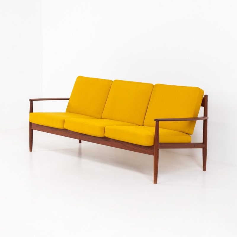 “FD-128” 3-seater by Grete Jalk for France & Son (Denmark, 1960s). This elegant masterpiece is a fine example of Scandinavian modernism. It features a solid teak frame with a warm natural grain, stunning curves and comfortable cushions, upholstered in a yellow fabric. The sofa presents itself in very good condition with only minor wear on the fabric. Labeled by maker.