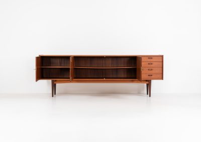 Stunning XL sideboard in teak by Bartels Werken (Germany, 1960s). A beautiful sleek sideboard featuring three doors and four drawers with beautiful inset handles. It has a warm and natural woodgrain which gives this rather minimalistic piece an elegant appearance. Its in amazing condition!