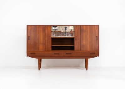 Teak highboard by P. Westergaard (Denmark, 1960s). This beautiful highboard comes with four sliding Doors and two wide drawers. It has beautiful teak wood patterns, nice inset handels and tons of storage space on the inside. Its in very good vintage condition with a few repair marks and small age related using traces. Labeled by maker.